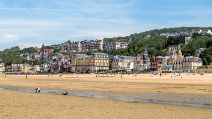 Panoramic view of the beach of Trouville and beautiful luxury buildings along the beach at low tide. Famous resort and fishermen village in Normandy, France. 