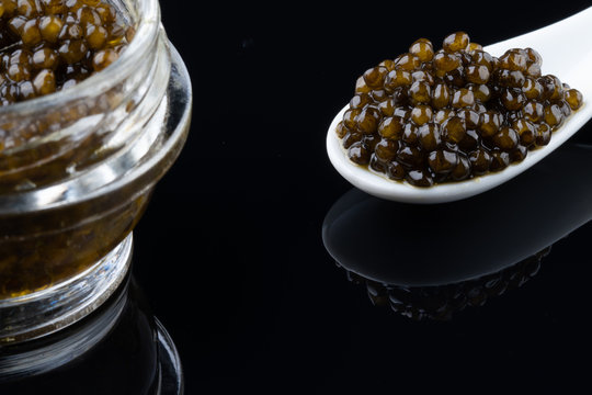 Black sturgeon caviar in ceramic spoon. macro