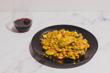 healthy lentils beans and vegetable curry recipe with wine glass on marble table