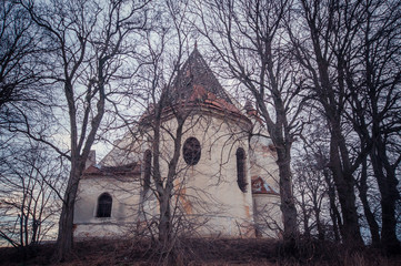 Fototapeta na wymiar Old abandoned orhodox church inside the trees