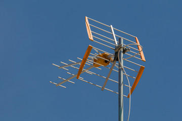 television antenna on a rooftop in front of a blue sky