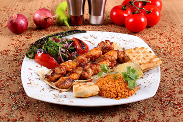 Chicken Kebab Chicken Serving with Gravy and Fresh Vegetables on White Plate on Table Filled with Spicy Spices