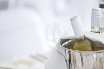 Wine bottles in an ice bucket on the restaurant table, white wine