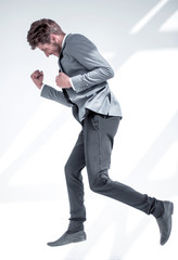 business style. Handsome young man in full suit jumping against white background