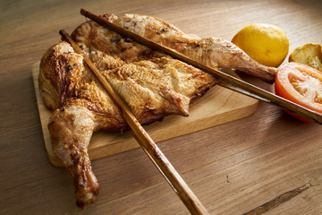 roasting chicken with tomato and lemon on wood table