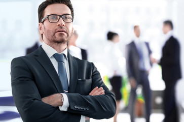 Businessman standing near the window and looking into it