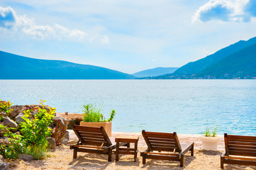 Chaise lounges on the beach in Kotor bay, Montenegro. Beautiful summer landscape