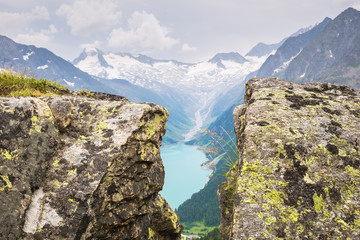 Scenic view from between the rocks of a lake and glacier in the Alps at the border of Austria and Italy