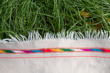 Woolen picnic cloth or blanket on grass top view.