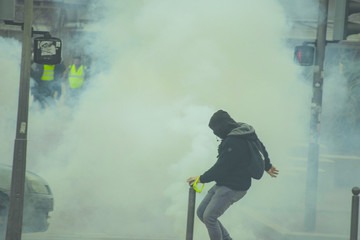 Manifestants renvoyant des grenades lacrymogènes durant une manifestation.
