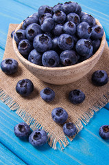 Raw fresh huckleberry in a bowl. Wooden background.