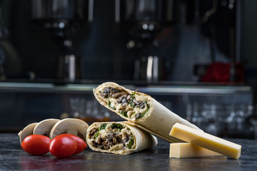 Obraz premium Shawarma sandwich gyroscope fresh roll of lavash Lavash chicken beef Shawarma falafel recipe tin eats stuffed with roasted meat, mushrooms, cheese. Traditional middle Eastern snack.