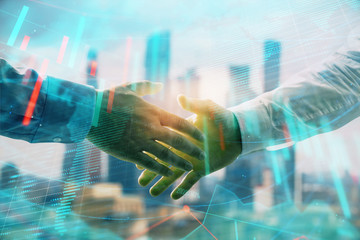 Double exposure of financial chart and world map on cityscape background with two businessmen handshake. Concept of international investment