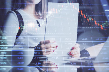 Double exposure of hands making notes with forex chart huds. Stock market concept.