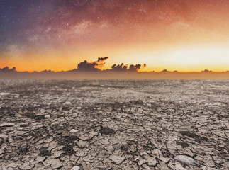 Dry cracked drought ground on sunrise sky 