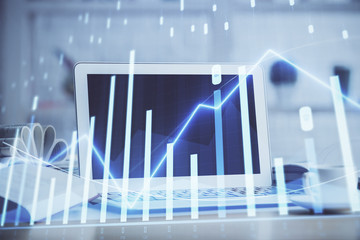 Forex graph hologram on table with computer background. Multi exposure. Concept of financial markets.