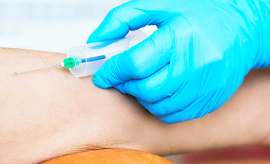 Health and Medical concept. Hands nurse are using needle to pierce vein Preparation for blood test on table.