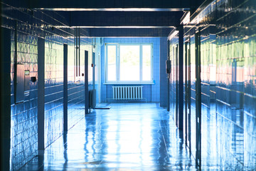 Blurry photo of hospital walk way with bright blue lighting. White floor with cool tone color with...