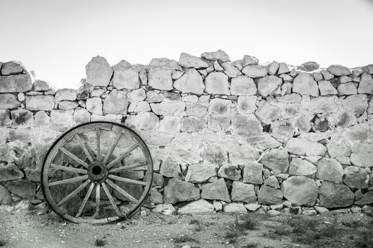 Rustic wagon wheel and stone wall