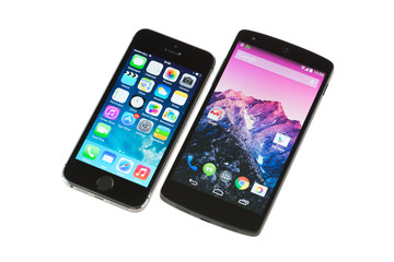 Kiev, Ukraine - September 29, 2014: Close-up shot of Apple iPhone 5S and Google Nexus 5 smartphones isolated on white background.