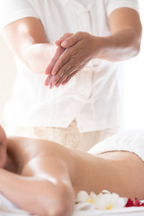 Asian women are undergoing a salt scrub body massage at a health spa. focus on hands