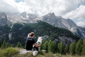 Naklejka premium dog with a man in the mountains at sunrise. travel with a pet.