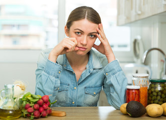 Sad tired young woman in the kitchen