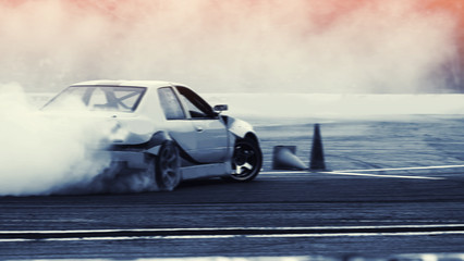 Fototapeta na wymiar Motion blur speed car drifting with rubber smoke by professional driver on speed track racing.