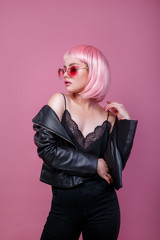 Stylish portrait of woman in sunglasses with bright colored pink hair and pink make-up in sunglasses