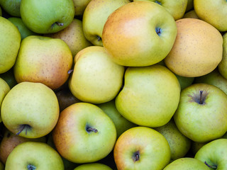 Fresh green apples lie in a box, top view.