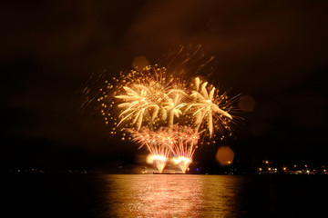 Beautiful colorful fireworks in sky over river. Big festive evening event with great pyrotechnic show.  