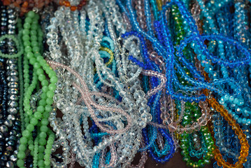 Necklace of colorful stones on the table. Many different jewelry and beads made of natural precious minerals. Transparent stones are sold at the fair.