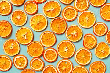 Bright dry orange slices on the blue table
