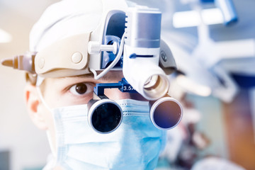 Portrait of spinal surgeon in operating room with surgery equipment.