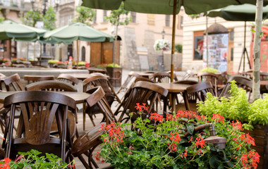 Closed cafe restaurant with wood chairs, stacked upon tables outdoor in Lviv, Ukraine