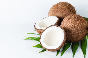 Ripe half cut coconut with green leaves on a white background. Isolated concept.