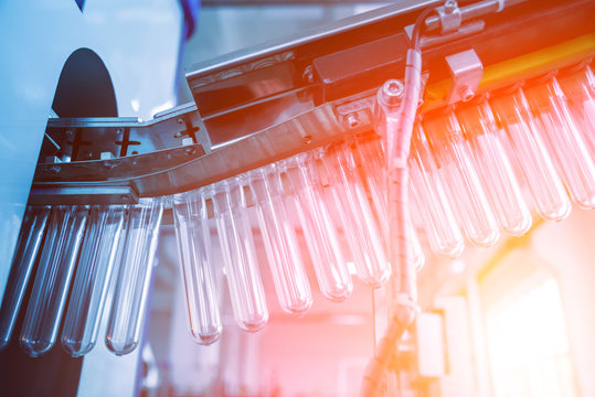 The plastic bottle blowing machine. PET preforms for blowing of plastic bottles. Heating process.