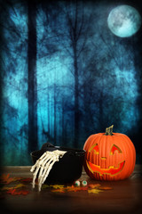 halloween pumpkin with skeleton hand and cauldron