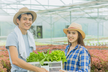 Young farmer holding a basket of vegetables and smiling happily in organic farming. The idea to use chips makes the happiness of the young generation.