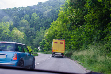 Road with car and truck seen from a car during driving