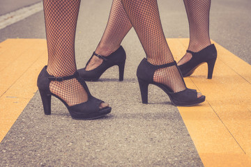 Two elegant woman wearing high heeled black shoes