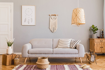 Stylish and design home interior of living room with gray sofa, wooden cube, commode, pillow, macrame, rattan lamp, basket, plants and elegant accessories. Stylish home decor. Template. Mock up poster