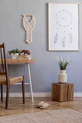 Design home interior of living room with stylish chair and wooden desk, plants, cube, mock up poster frame, white macrame and elegant accessories. Stylish home decor. Template. Gray walls. 