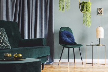 Design composition of living room interior with green vlvet sofa and chair, stylish coffee table,...