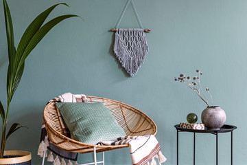 Stylish minimalistic interior of living room with design rattan armchair, black coffee table,...