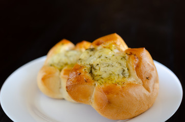 Homemade buns in white plate on wooden background