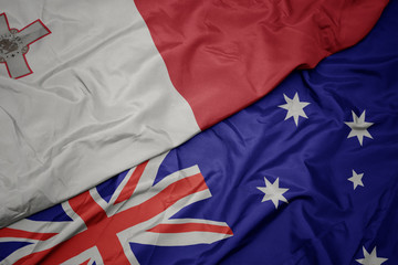 waving colorful flag of australia and national flag of malta.