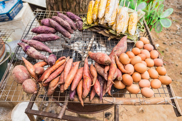 Sweet potato and egg grilled on stove in countryside store.Thailand.