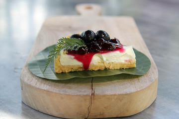 Delicious blueberry cheesecake on wood plank.