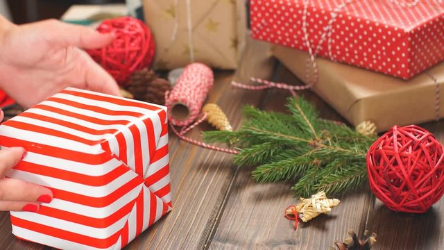 Christmas presents wrapped in eco paper with homemade decoration on wooden background with decor elements.